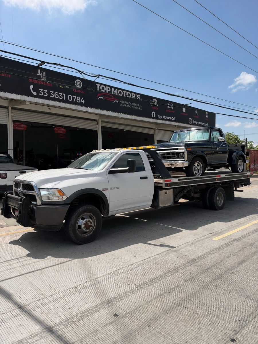Ford pickup clásica sobre la plataforma frente a un taller mecánico